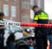 Situatie op straat met politiemedewerkers en een rood-wit lint met 'Niet betreden'